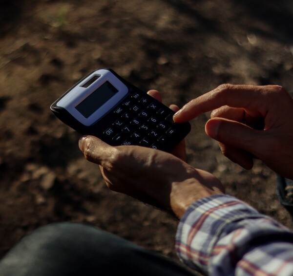 bonde med kalkulator på et jorde